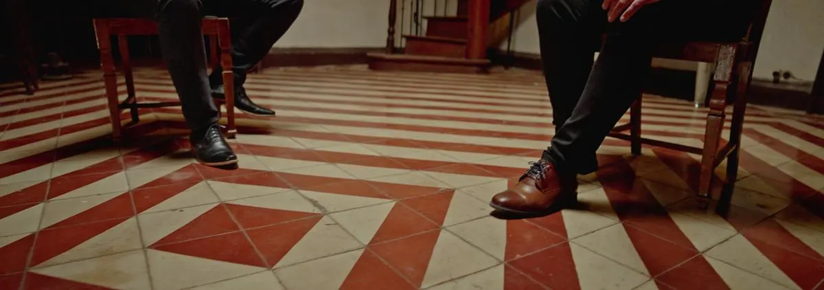 Los pies de ambos sobre las baldosas rojas y blancas