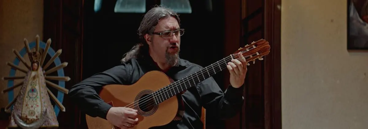 Guitarrista cantando junto a la imagen de la Virgen