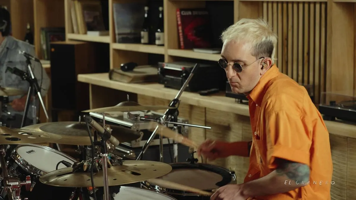 El baterista de camisa naranja durante la toma