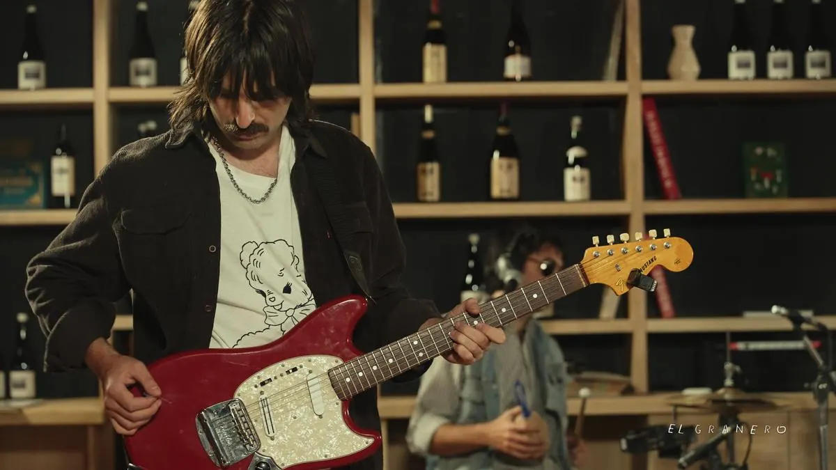 Guitarrista con una Fender Mustang roja