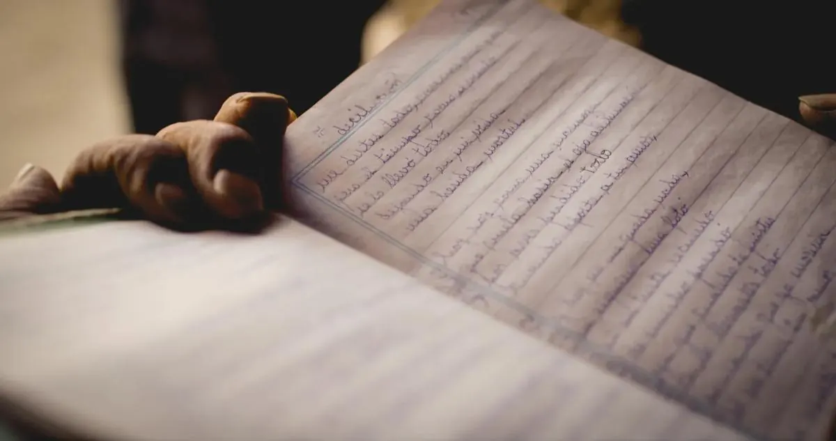 Manos sosteniendo un cuaderno escrito a mano