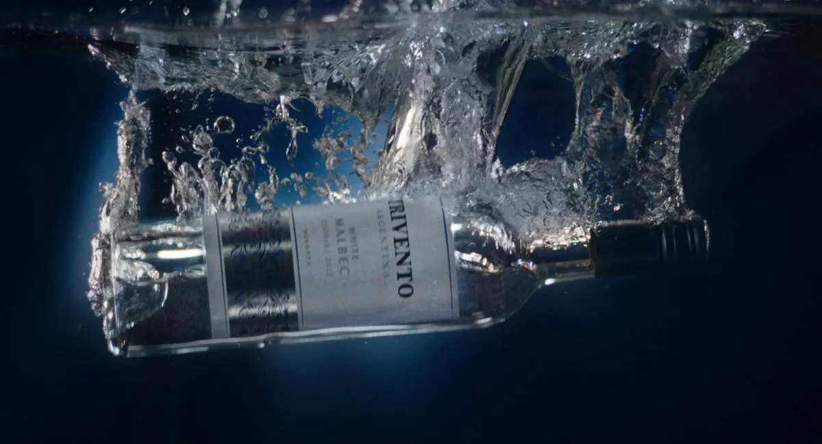 Botella de Trivento White Malbec cayendo dentro del agua